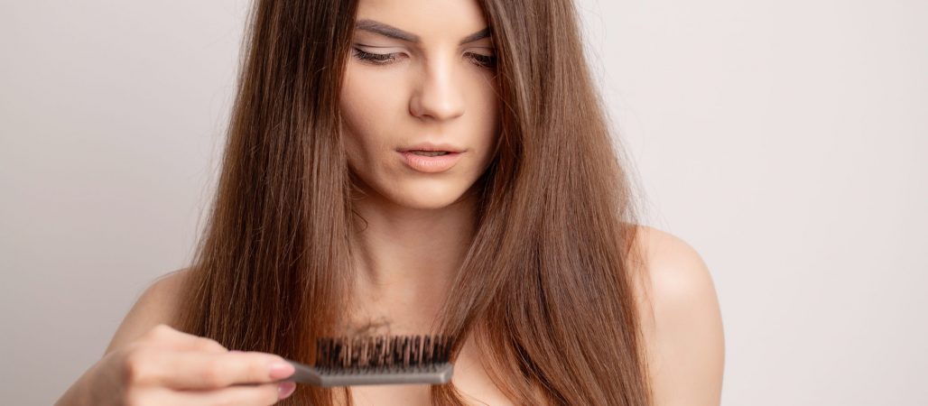 Very upset young woman with comb and problem loss hair